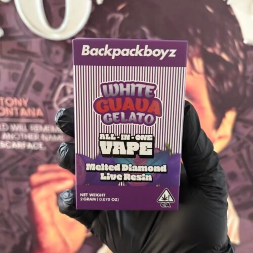 Hands in black gloves hold a purple Backpackboyz All-in-One Vape box labeled 'White Guava Gelato'